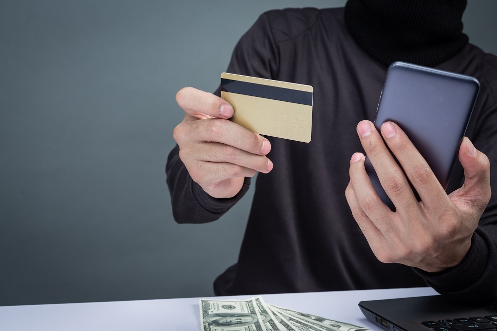 thieves_wear_a_black_hat_hold_the_phone_and_a_smart_card_on_gray.jpg thieves_wear_a_black_hat_hold_the_phone_and_a_smart_card_on_gray.jpg